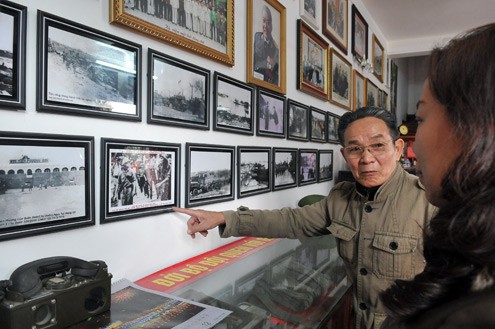 Cựu chiến binh Nguyễn Mạnh Hiệp đang giới thiệu với bạn bè và khách tham quan về những kỷ vật thời chiến. Ảnh: Hoàng Hà.